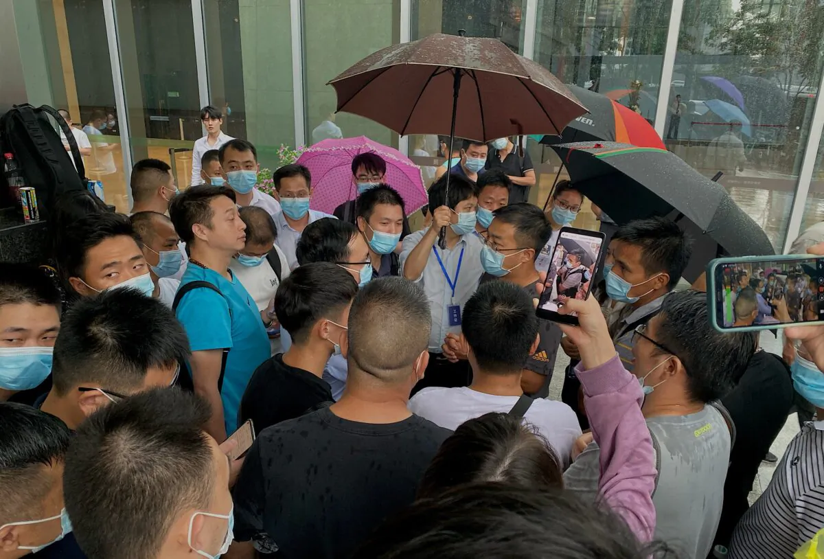 People gather outside the Evergrande headquarters in Shenzhen, southeastern China, on Sept. 14, 2021. (Noel Celis/AFP via Getty Images)