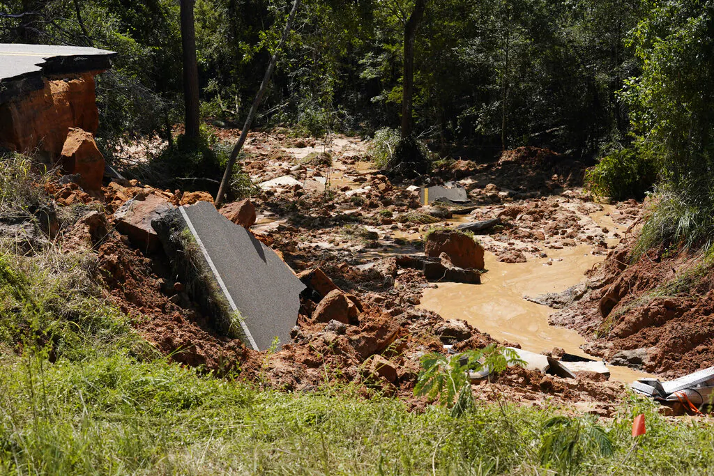 Vehicle debris are mixed with torn road sections of Mississippi Highway 26, in the Crossroads community, on Aug. 31, 2021. (Rogelio V. Solis/AP Photo)