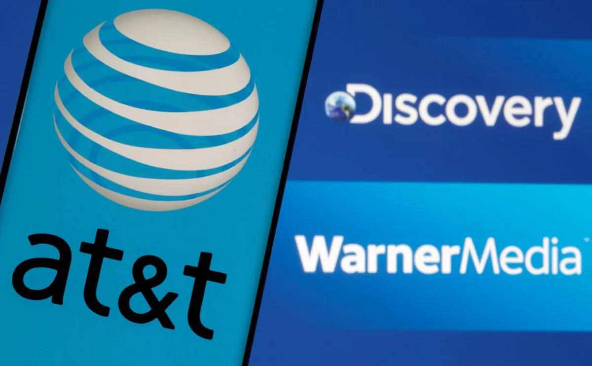 The AT&T logo is seen on a smartphone in front of displayed Discovery and Warner Media logos in this illustration taken on May 17, 2021. (Dado Ruvic/Reuters)