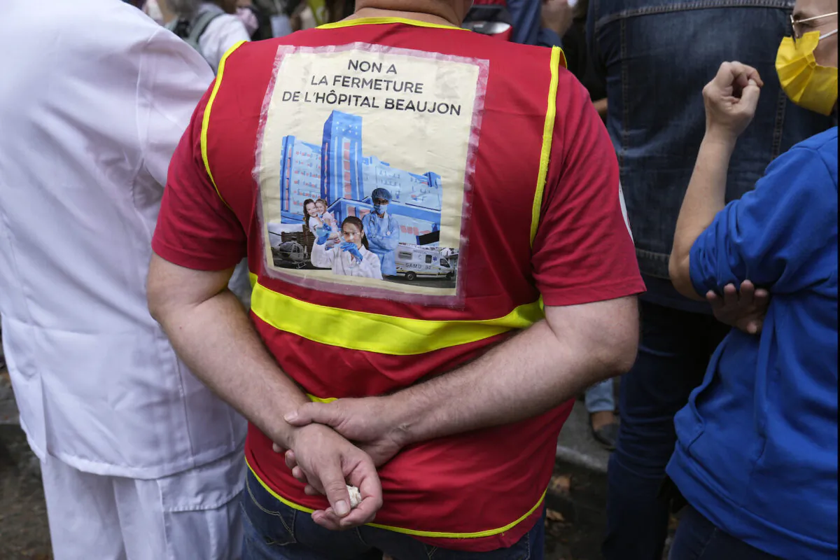 A medical worker holds a placard reading: "No at closing of the Beaujon Hospital," during a protest gathering outside the Health Ministry, in Paris on Sept. 14, 2021. (Francois Mori/AP Photo)