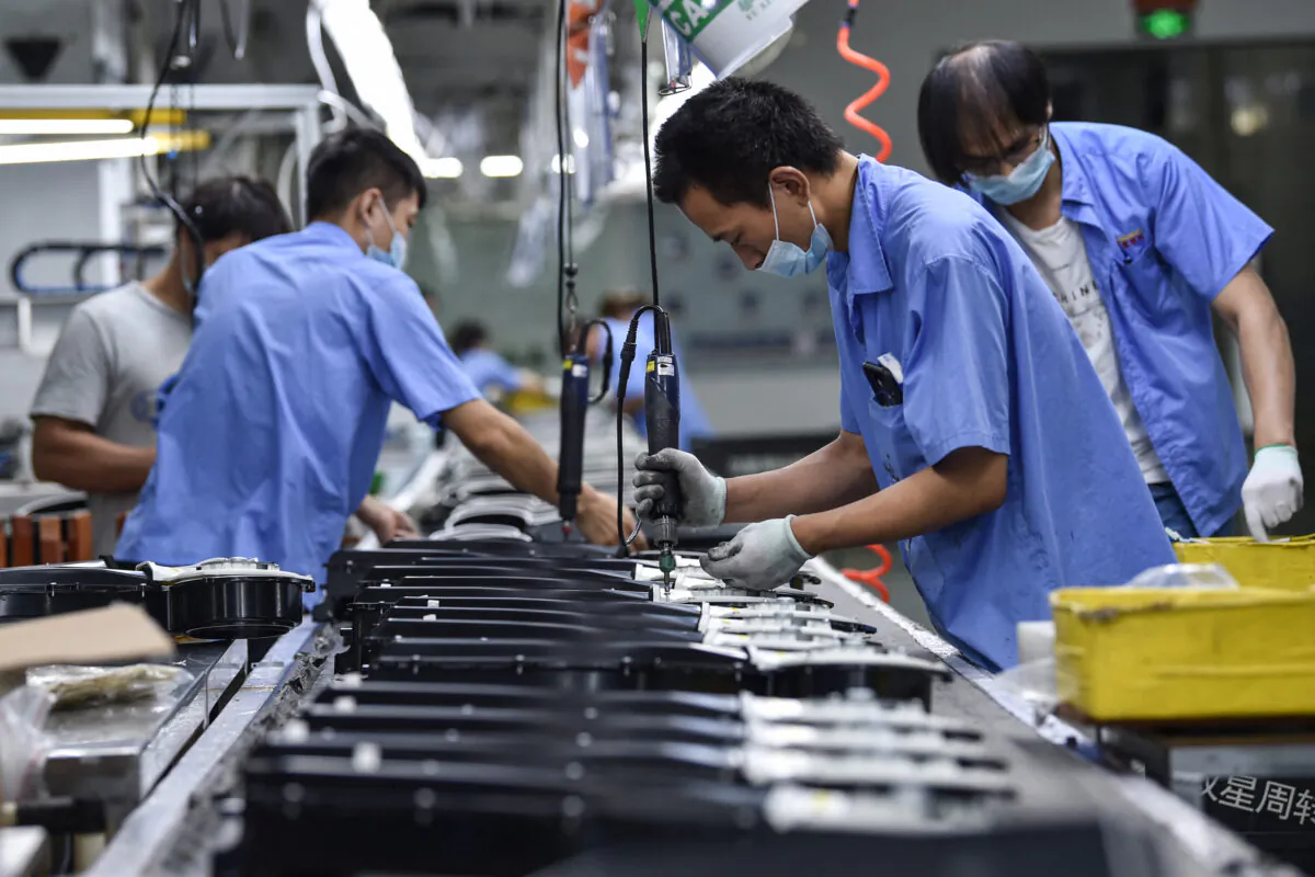 Workers produce washing machine parts at a factory in Nanjing, in China's eastern Jiangsu Province on Aug. 16, 2021. (STR/AFP)