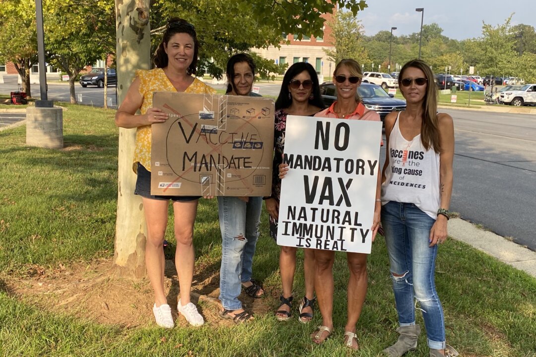 Michelle Friel (L), Lisa Hamm (2nd L), Heather Metz (2nd R), and Kelly Peter (R) protest outside the Loudoun County Public Schools administration building in Ashburn, Va., on Sept. 14, 2021. (Terri Wu/The Epoch Times)