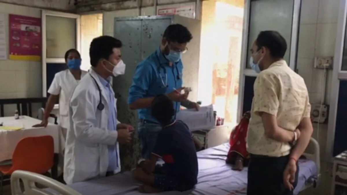 In this screenshot from video, doctors examine a child sitting on hospital bed in India, on Sept. 15, 2021. (AP via NTD)