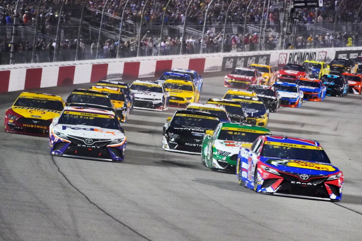 Denny Hamlin (11) and Martin Truex Jr., (19) lead the field at the start of the NASCAR Cup series auto race in Richmond, Va., on Sept. 11, 2021. (Steve Helber/AP Photo)