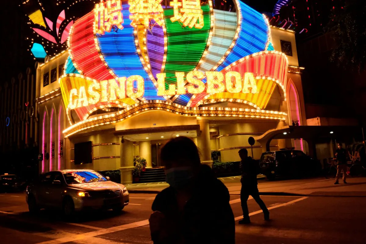 People wearing masks walk in front of Casino Lisboa, before its temporary closing, following the coronavirus outbreak in Macau, China on Feb. 4, 2020. (Tyrone Siu/Reuters)