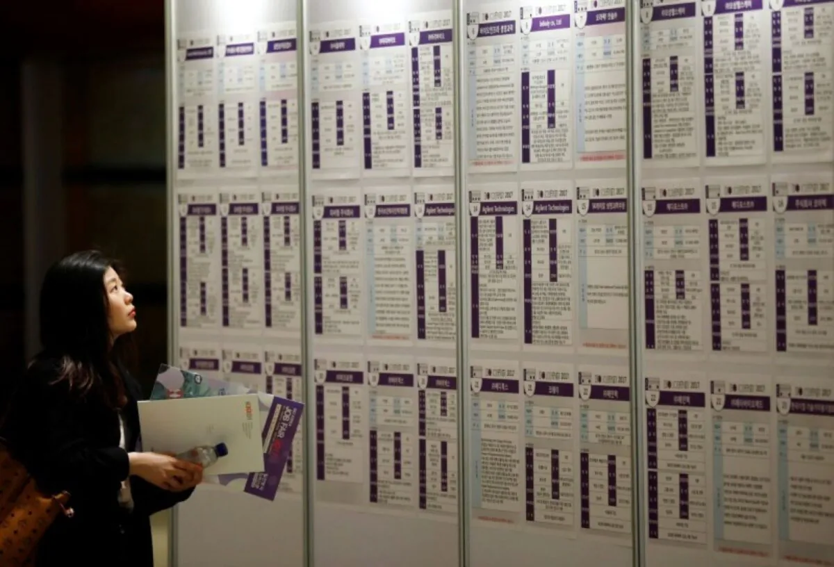 A woman looks at recruiting information during a job fair in Seoul, South Korea on April 12, 2017. (Kim Hong-Ji/Reuters)