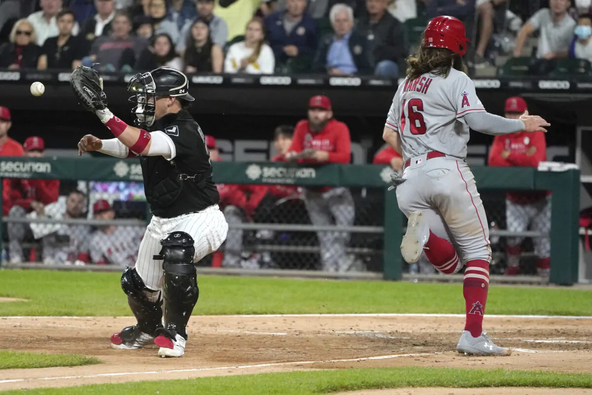 Los Angeles Angels' Brandon Marsh (16) scores past Chicago White Sox catcher Yasmani Grandal during the sixth inning of a baseball game in Chicago on Sept. 15, 2021. (AP Photo/Charles Rex Arbogast)