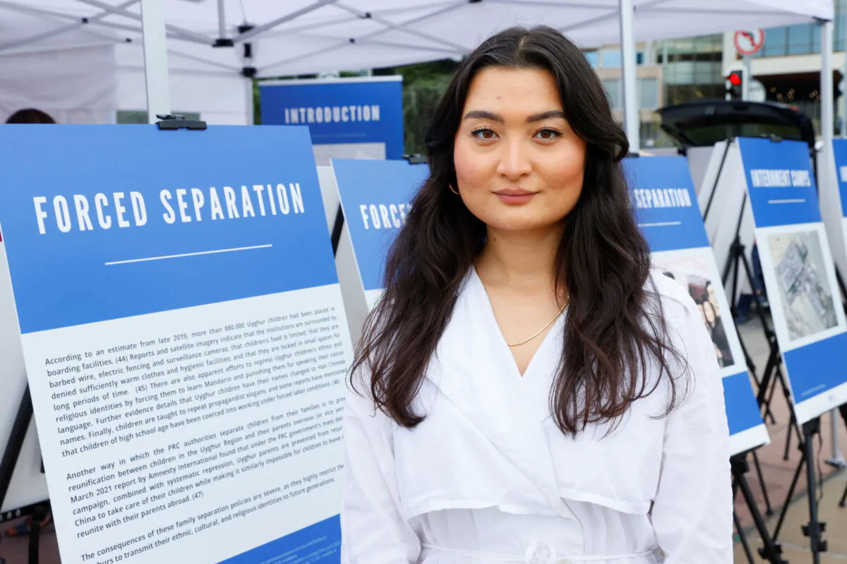 Zumretay Arkin, Program and Advocacy Manager at the World Uyghur Congress, poses at a U.S.-backed Uyghur photo exhibit of dozens of people who are missing or alleged to be held in Chinese-run camps in Xinjiang, in front of the United Nations in Geneva, Switzerland, on Sept. 16, 2021. (Denis Balibouse/Reuters)