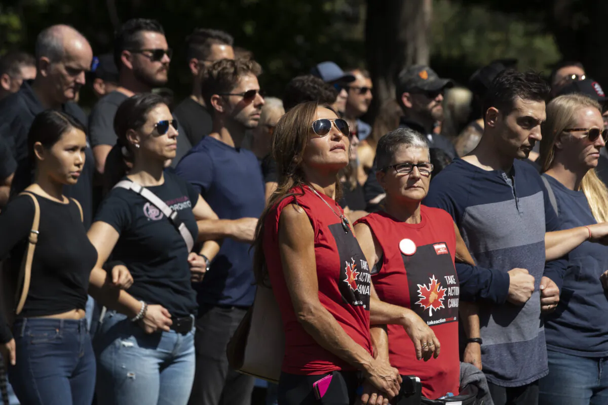 A group of front-line workers including healthcare professionals and members of the police and fire service protest vaccine mandates outside the Ontario Legislature in Toronto, on Sept. 13, 2021. (The Canadian Press/Darryl Dyck)