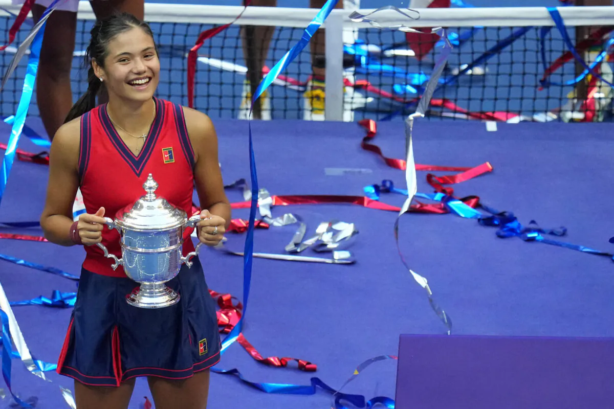 Emma Raducanu of Great Britain celebrates with the championship trophy after her match against Leylah Fernandez of Canada (not pictured) in the women's singles final on day thirteen of the 2021 U.S. Open tennis tournament at USTA Billie Jean King National Tennis Center in Flushing, New York, on Sep 11, 2021. (Danielle Parhizkaran/USA TODAY Sports via Reuters)