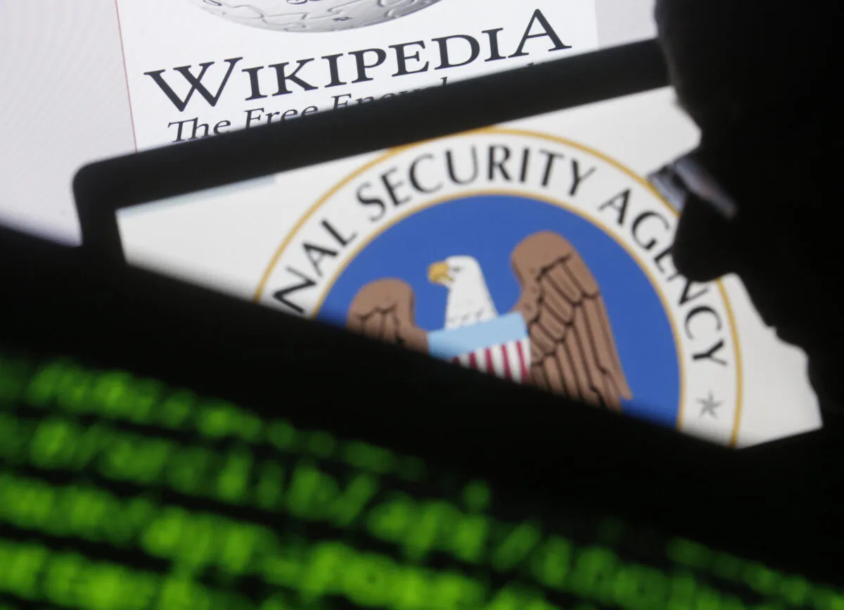 A man is seen near cyber code and the U.S. National Security Agency logo in this photo illustration taken in Sarajevo March 11, 2015. (Dado Ruvic/Reuters, Files)