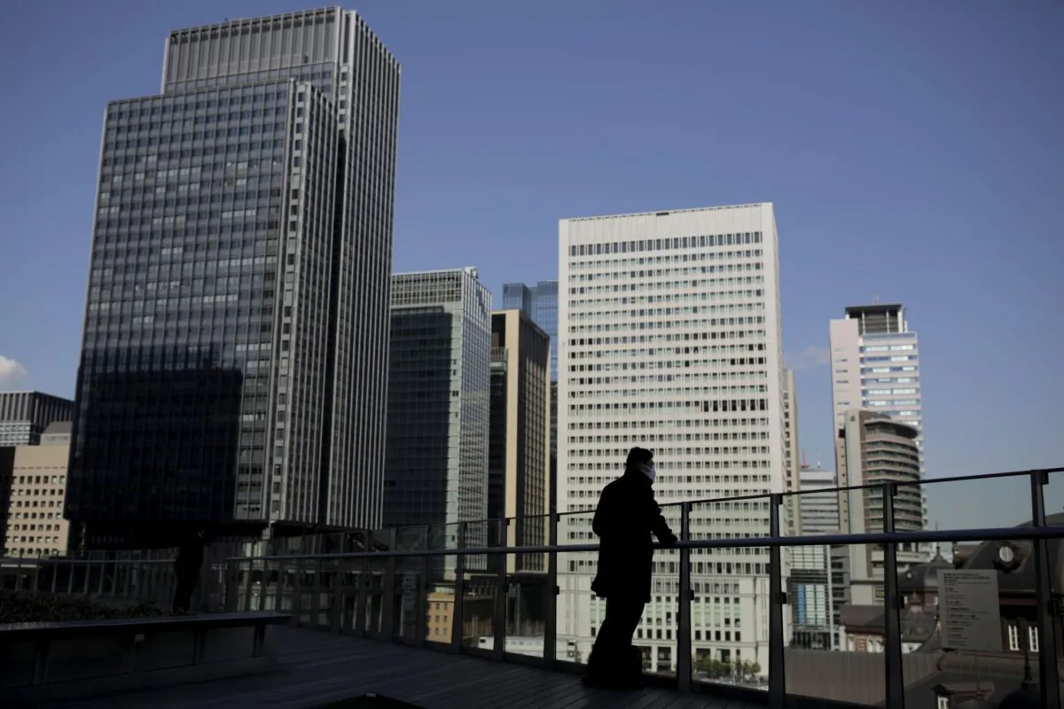 A businessman stands on a terrace overlooking a banking district in Tokyo, Japan on Feb. 16, 2016. (Thomas Peter/Reuters)