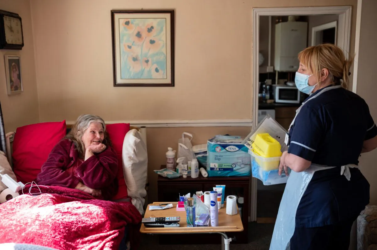 Team leader for housebound vaccinations, Julie Fletcher says goodbye after administering a dose of AstraZeneca/Oxford Covid-19 vaccine to housebound patient Gillian Marriott at her home in Hasland, near Chesterfield, central England on April 14, 2021. (OLI SCARFF/AFP via Getty Images)