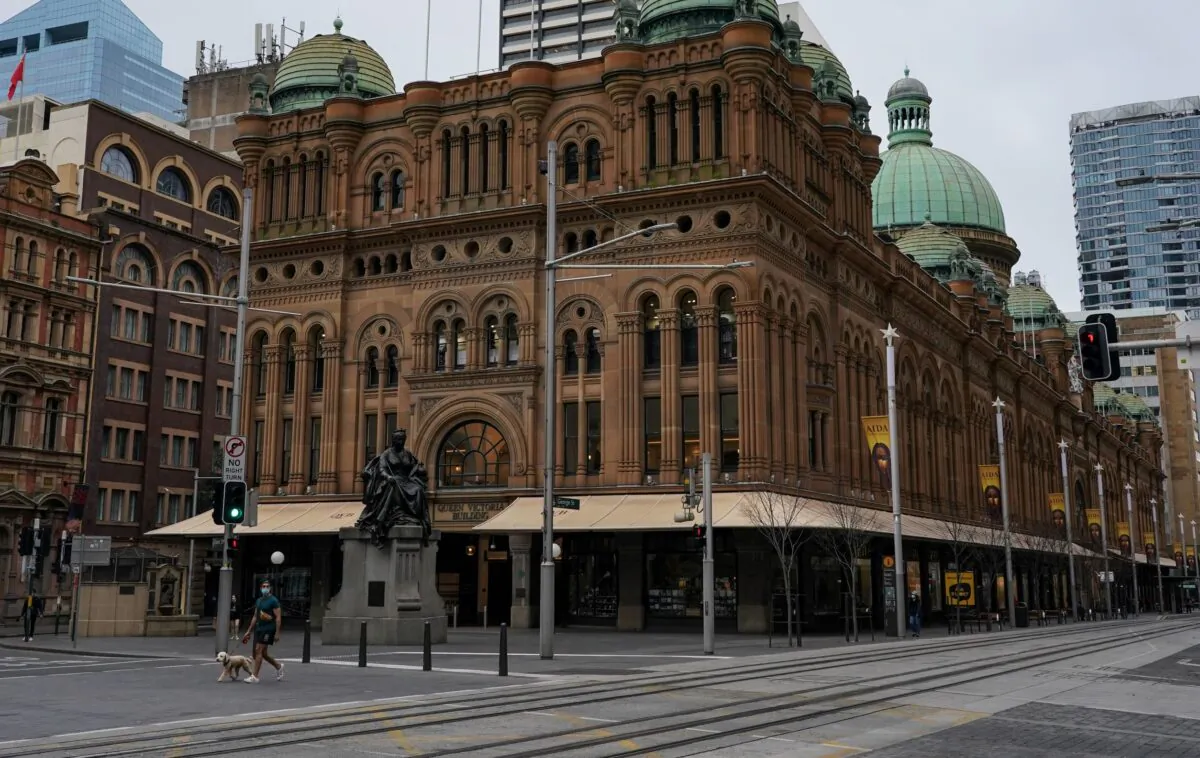 A masked man walks a dog through the quiet city centre during a lockdown to curb the spread of a coronavirus disease outbreak in Sydney, Australia on Aug. 23, 2021. (Loren Elliott/Reuters)