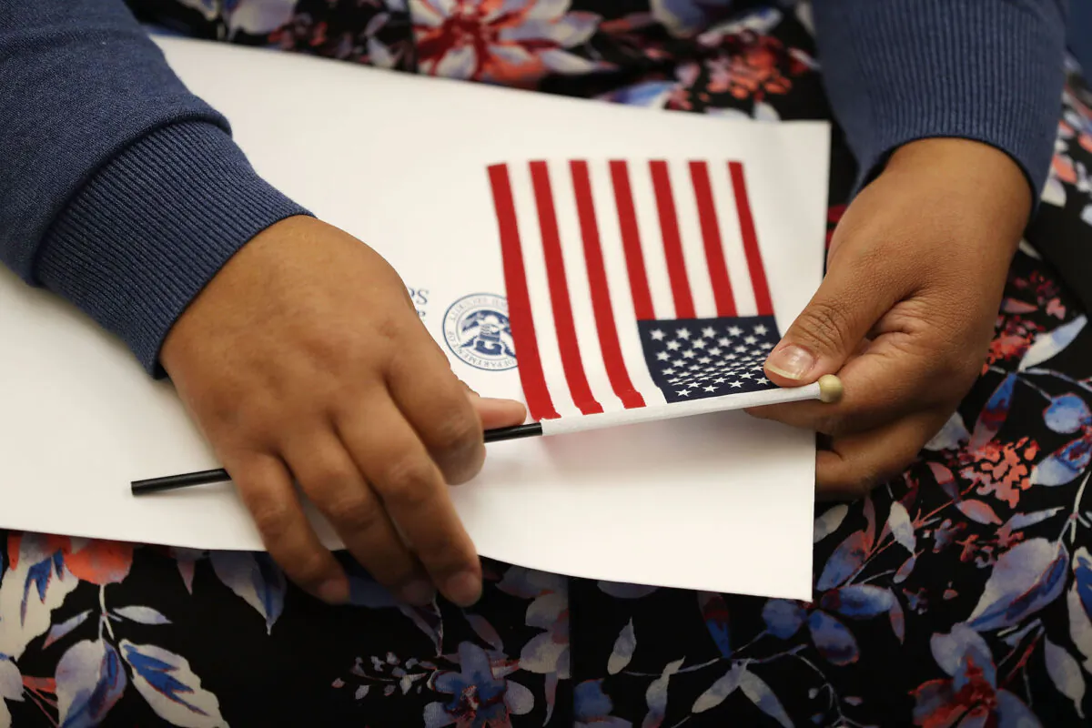 A person holds an American flag at a U.S. Citizenship & Immigration Services naturalization ceremony in Miami, Fla., on Aug. 17, 2018. (Joe Raedle/Getty Images)