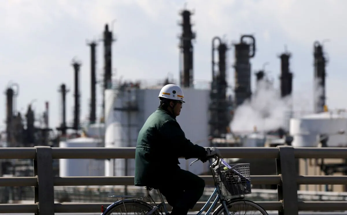 A worker cycles near a factory at the Keihin industrial zone in Kawasaki, Japan, on Feb. 17, 2016. (Toru Hanai/Reuters)
