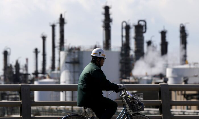 A worker cycles near a factory at the Keihin industrial zone in Kawasaki, Japan, on Feb. 17, 2016. (Toru Hanai/Reuters)