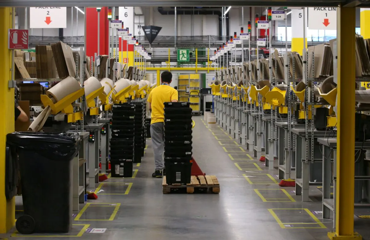 A worker moves boxes at a packaging area inside Amazon distribution center in El Prat de Llobregat, near Barcelona, Spain on March 15, 2018. (Albert Gea/Reuters)