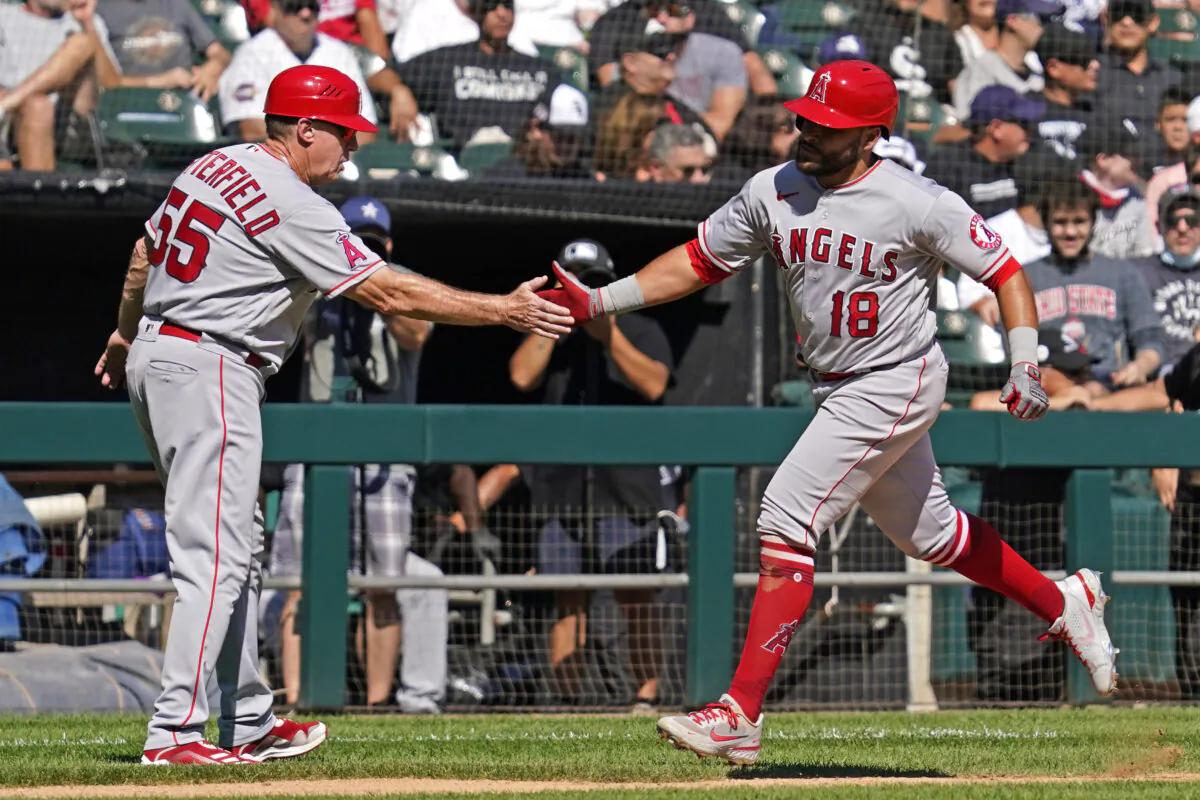 Los Angeles Angels' Jose Rojas, right, celebrates with third base coach Brian Butterfield after hitting a two-run home run during the fourth inning of a baseball game against the Chicago White Sox in Chicago on Sept. 16, 2021. (AP Photo/Nam Y. Huh)