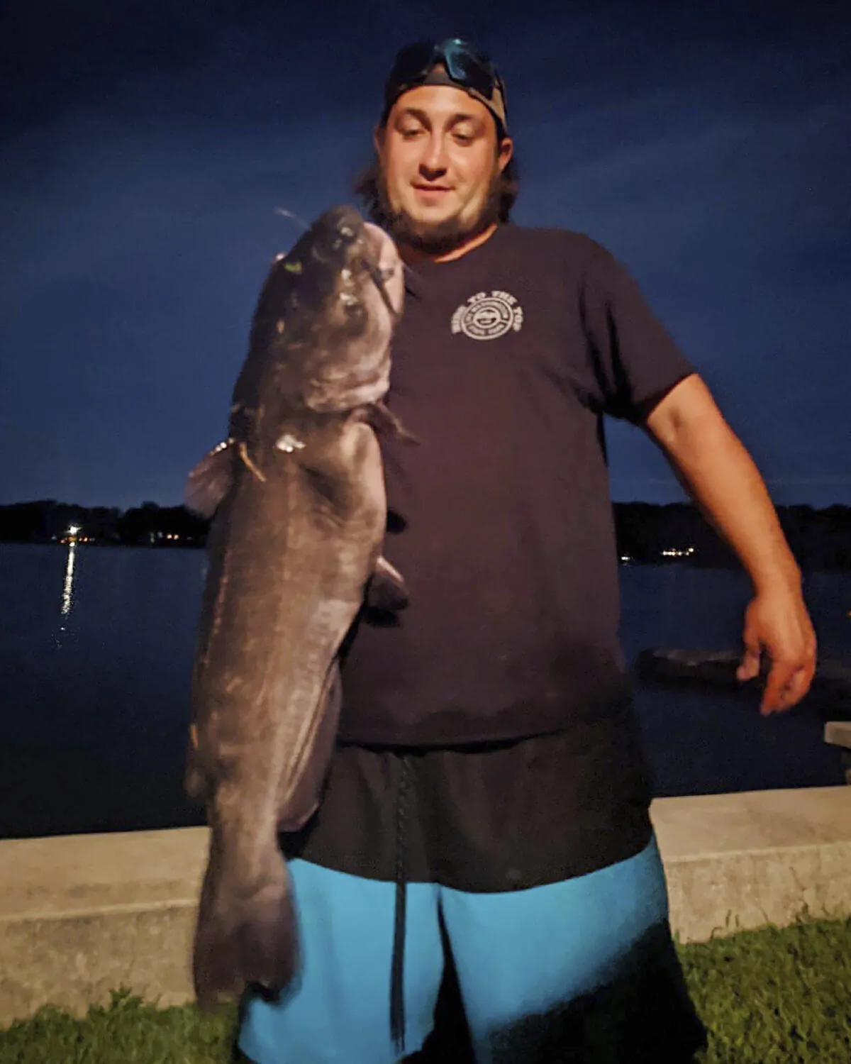 Ben Tomkunas holds a catfish he caught in Coventry, Conn., on Aug. 21, 2021. (Chris Braga via AP)
