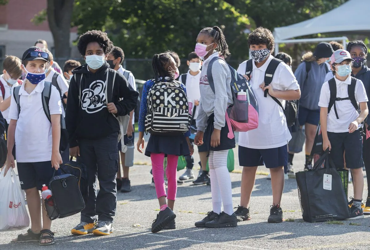 Students line up before classes start on the first day of the school year, in Montreal on Aug. 31, 2021. (The Canadian Press/Graham Hughes)