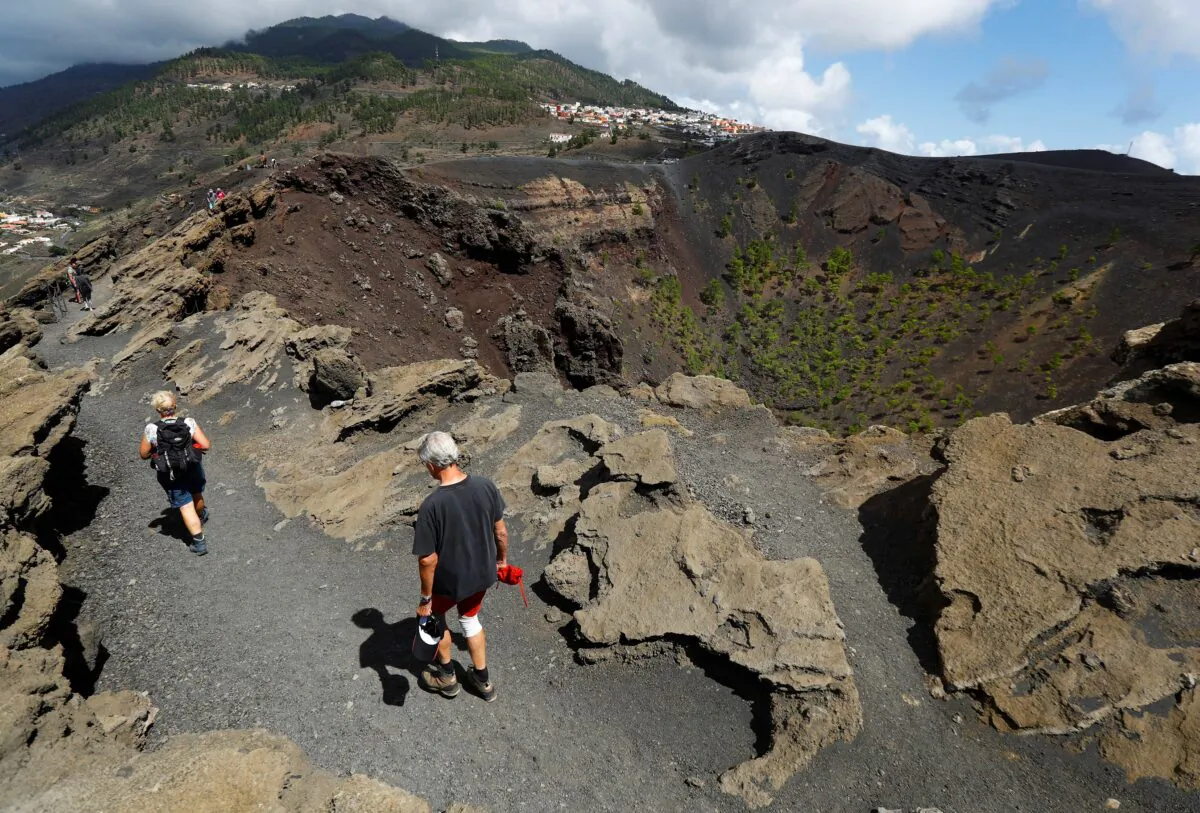 Tourists walk next to the crater of the San Antonio Volcano on the Canary Island of La Palma, Spain, on Sept. 17, 2021. (Borja Suarez/Reuters)