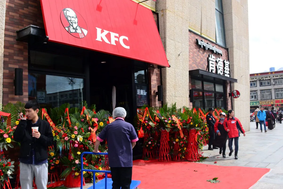 People walk past a KFC fast food restaurant in Lhasa, Tibet, on March 8, 2015. (STR/AFP via Getty Images)