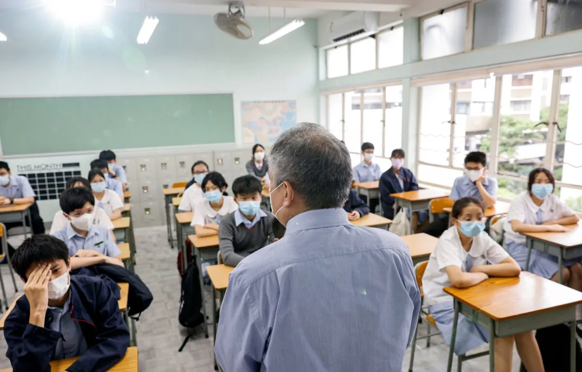 A teacher introduces himself to the students in a classroom at a secondary school, during the first day of the new term, in Hong Kong on Sept. 1, 2021. (Tyrone Siu/Reuters)