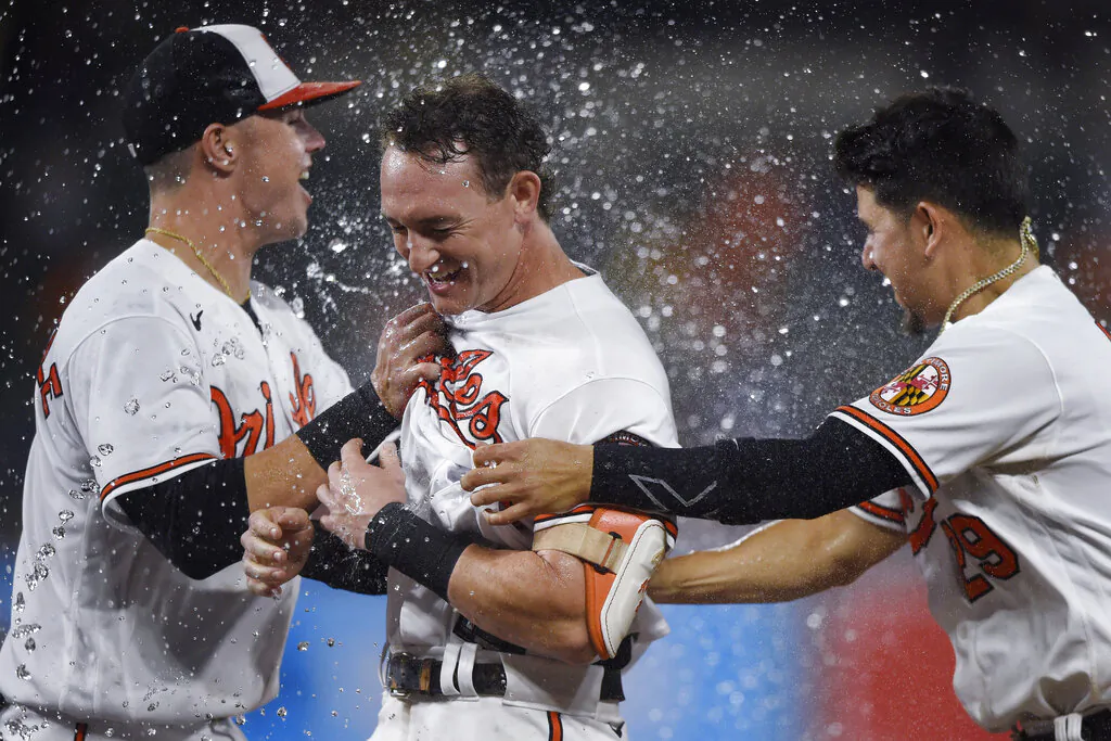 Baltimore Orioles' Austin Hays (C) is congratulated by Ryan Mountcaste (L) and Ramon Urias (R) after driving in the winning run against the New York Yankees during the 10th inning of a baseball game in Baltimore, Md., on Sept. 16, 2021. (Gail Burton/AP Photo)