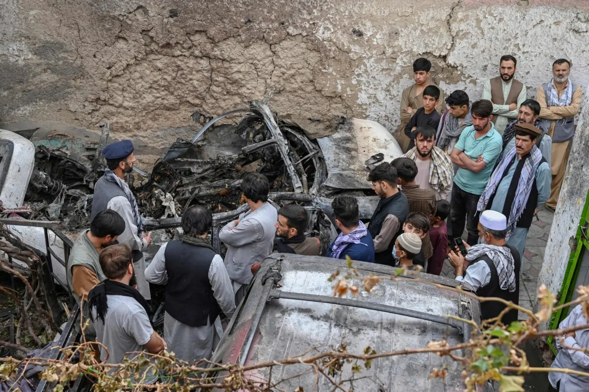 Afghan residents and family members of the victims gather next to a damaged vehicle inside a house the day after a U.S. drone airstrike in Kabul, Afghanistan, on Aug. 30, 2021. (Wakil Kohsar/AFP via Getty Images)