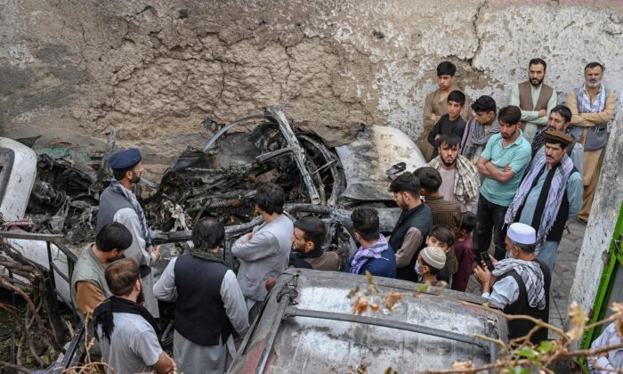 Afghan residents and family members of the victims gather next to a damaged vehicle inside a house, the day after a U.S. drone airstrike in Kabul, Afghanistan, on Aug. 30, 2021. (Wakil Kohsar/AFP via Getty Images)