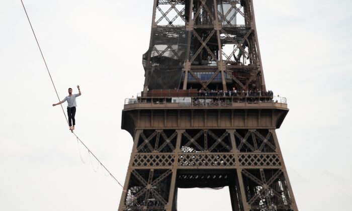 French acrobat Nathan Paulin walks the slackline between the Eiffel Tower and the Théâtre National de Chaillot as part of the National Heritage Day event in Paris, France, on September 18, 2021.  (Benoit Tessier / Reuters)