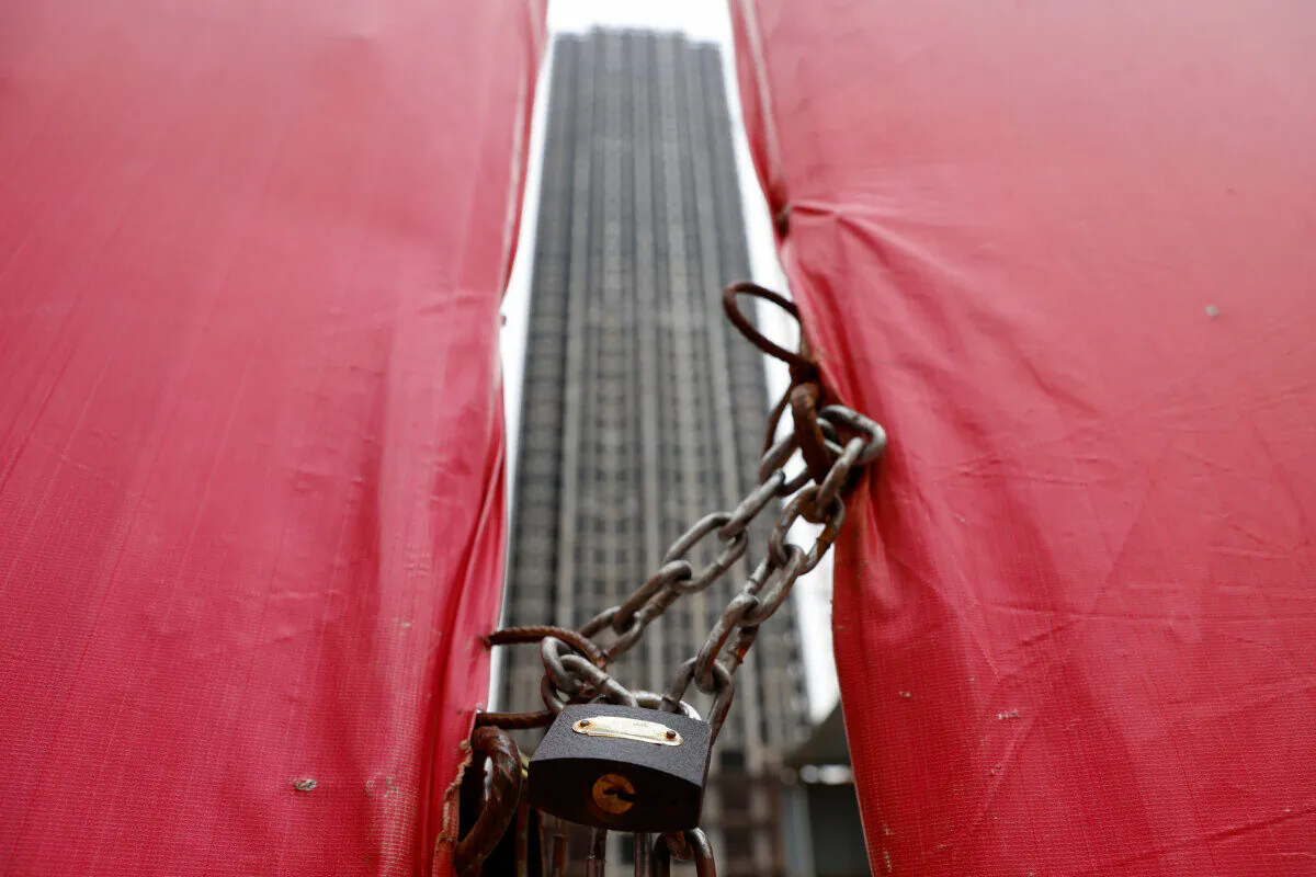 An unfinished residential building through a construction site gate at Evergrande Oasis, a housing complex developed by Evergrande Group in Luoyang city, China, on Sept. 16, 2021. (Carlos Garcia Rawlins/Reuters)