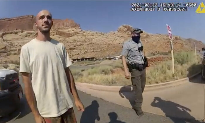 In this screenshot from a police camera video, Brian Laundrie talks to a police officer after police pulled over the van he was traveling in with his girlfriend, Gabrielle “Gabby” Petito, near the entrance to Arches National Park, Utah, on Aug. 12, 2021. ( Moab Police Department via AP)