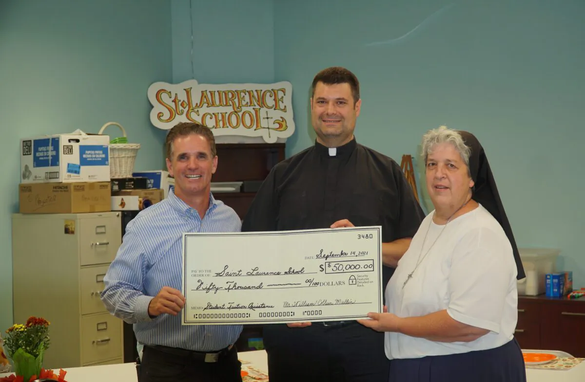 William Mullin (left) held the $50,000 check donated to St. Laurence School, with St. Laurence pastor Father Thomas Whittingham (middle) and Sister Regina Matulka, the school's principal. (Lily Sun/The Epoch Times)
