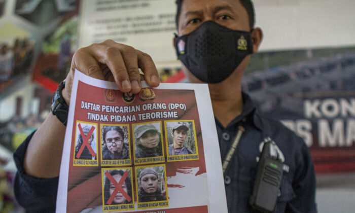 Police officers wanted to display portraits of two terrorist licarolas (top L) and Jakara Madan (bottom L) killed during a gun battle with security forces at a press conference at the central Parigi Mouton police station. Shows wanted poster September 19, 2021, Sulawesi, Indonesia.  (Mohammad Taufan / AP Photo)