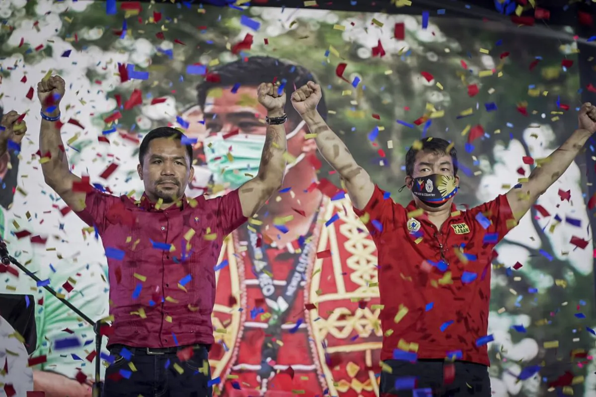 Senator Manny Pacquiao (L) raises his hands during a national convention of his PDP-Laban party in Quezon city, Philippines on Sept. 19, 2021. (Manny Pacquiao MediaComms via AP)
