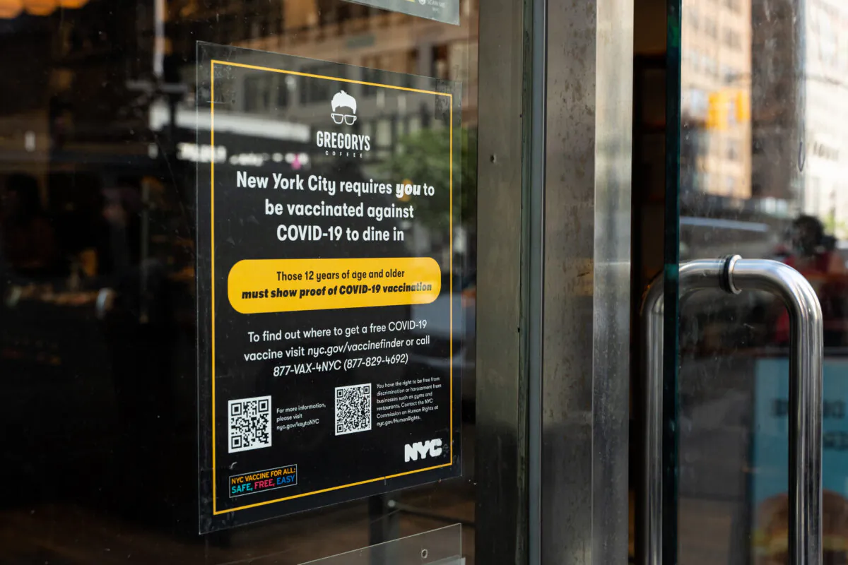 Vaccine proof requirement note displays at a restaurant store front in New York on Sept. 7, 2021. (Chung I Ho/The Epoch Times)