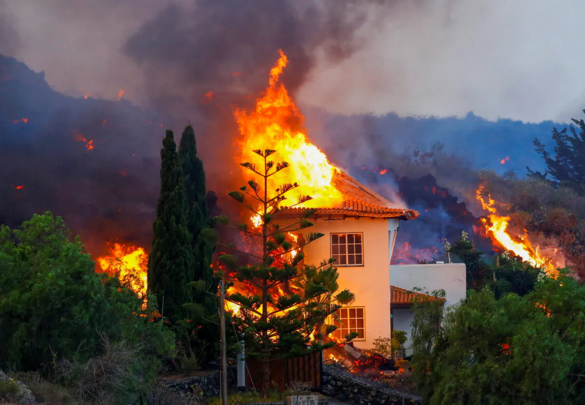 A house burns due to lava from the eruption of a volcano in the Cumbre Vieja national park at Los Llanos de Aridane, on the Canary Island of La Palma, on Sept. 20, 2021. (Borja Suarez/Reuters)