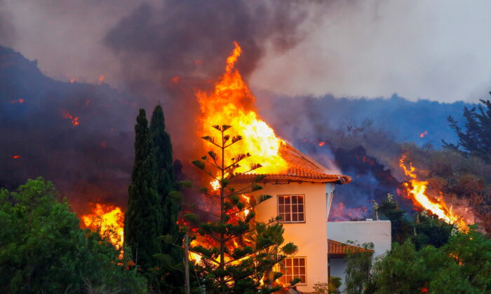 A house burns due to lava from the eruption of a volcano in the Cumbre Vieja national park at Los Llanos de Aridane, on the Canary Island of La Palma, on Sept. 20, 2021. (Borja Suarez/Reuters)