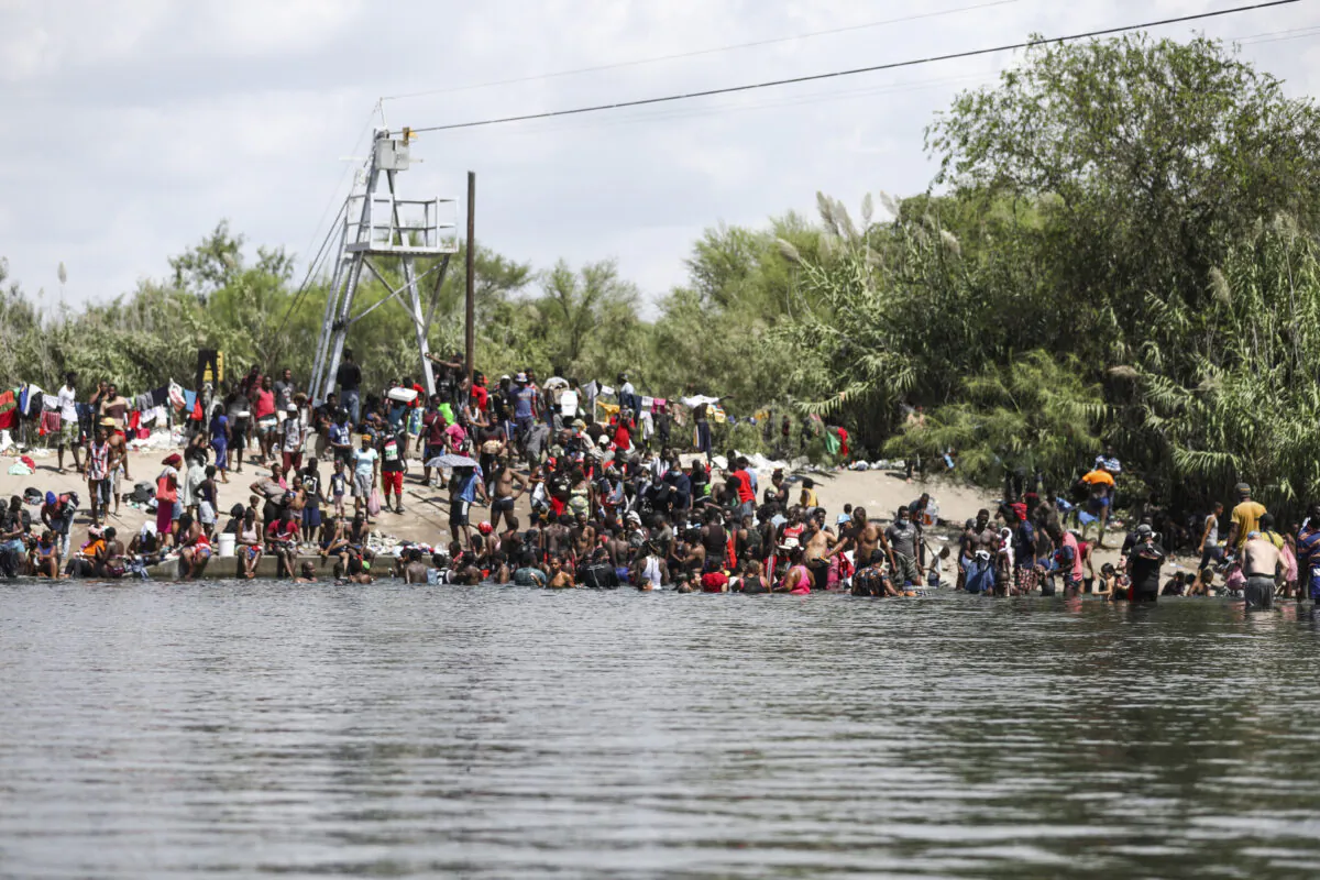 Illegal immigrants bathe and play on the U.S. side of the Rio Grande, the international boundary with Mexico, in Del Rio, Texas, on Sept. 18, 2021. (Charlotte Cuthbertson/The Epoch Times)