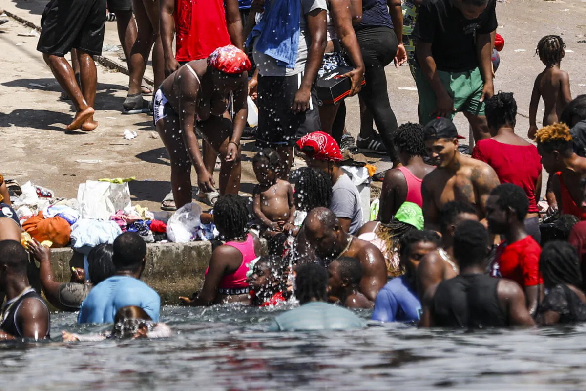 Illegal immigrants bathe and play on the U.S. side of the Rio Grande, the international boundary with Mexico, in Del Rio, Texas, on Sept. 18, 2021. (Charlotte Cuthbertson/The Epoch Times)