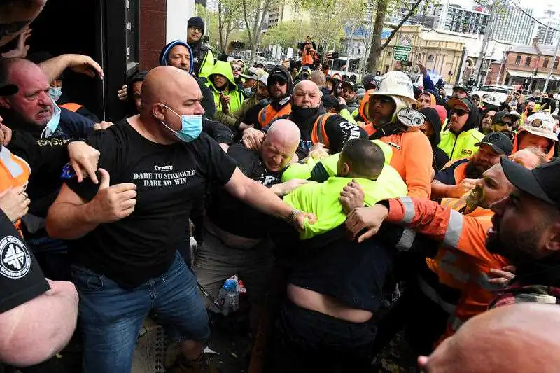 Construction workers clash with unionists at a protest at Construction, Forestry, Maritime, Mining and Energy Union (CFMEU) headquarters in Melbourne, Monday, Sept. 20, 2021. (AAP Image/James Ross) 