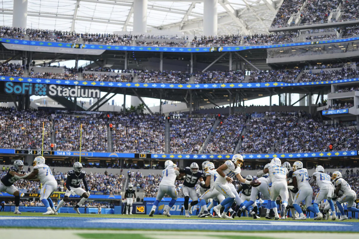 Los Angeles Chargers quarterback Justin Herbert hands off to running back Austin Ekeler (30) during the second half of an NFL football game in Inglewood, Calif., on Sept. 19, 2021. (AP Photo/Ashley Landis)