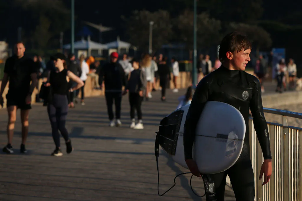 A surfer walks along the boardwalk at Bronte Beach in Sydney, Australia, on Sept. 11, 2021. (Lisa Maree Williams/Getty Images)