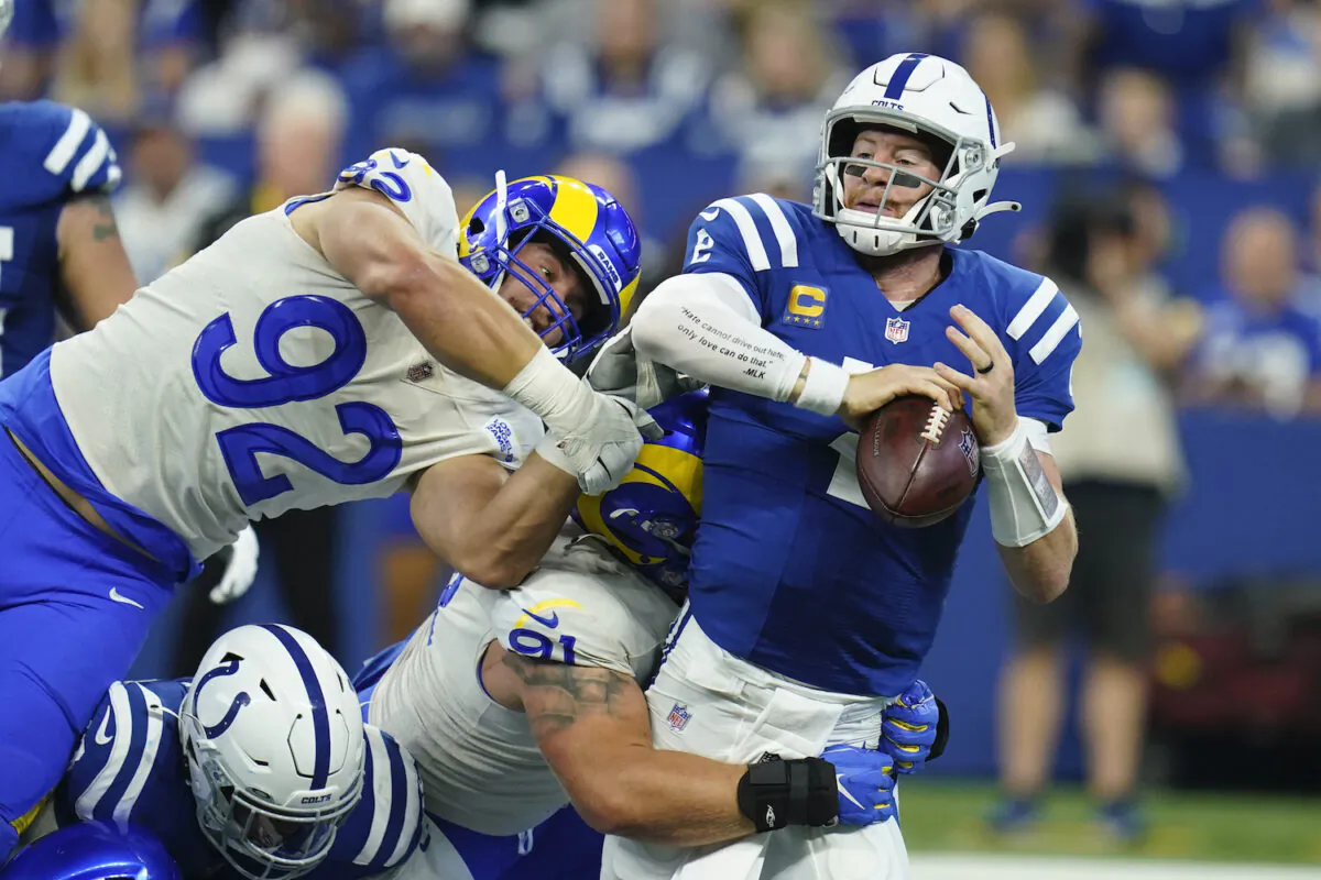 Indianapolis Colts quarterback Carson Wentz (2) is sacked by Los Angeles Rams' Greg Gaines (91) during the first half of an NFL football game in Indianapolis on Sept. 19, 2021. (AP Photo/Michael Conroy)