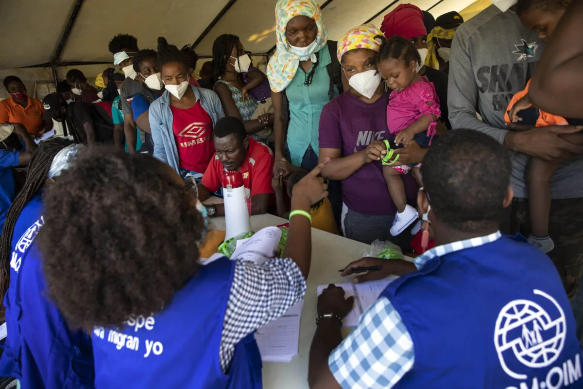 Haitians who were deported from the U.S. border with Mexico are attended by members of the IOM UN Migration organization before they get tested for COVID-19 at Toussaint Louverture International Airport in Port-au-Prince, Haiti, Sept. 20, 2021. (Joseph Odelyn/AP Photo)