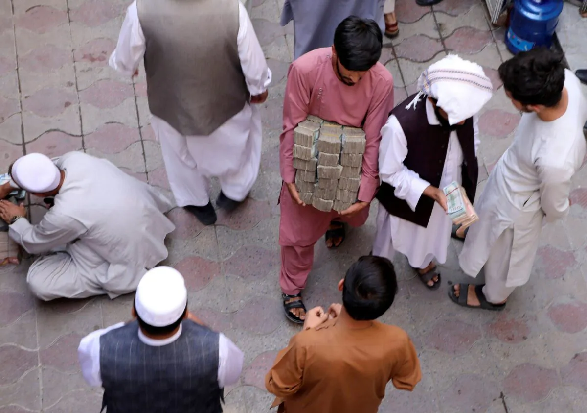 An Afghan money exchange dealer carries bundles of banknotes at an exchange market, following banks and markets reopening after the Taliban took over in Kabul, Afghanistan, on Sept. 4, 2021. (Stringer/Reuters)