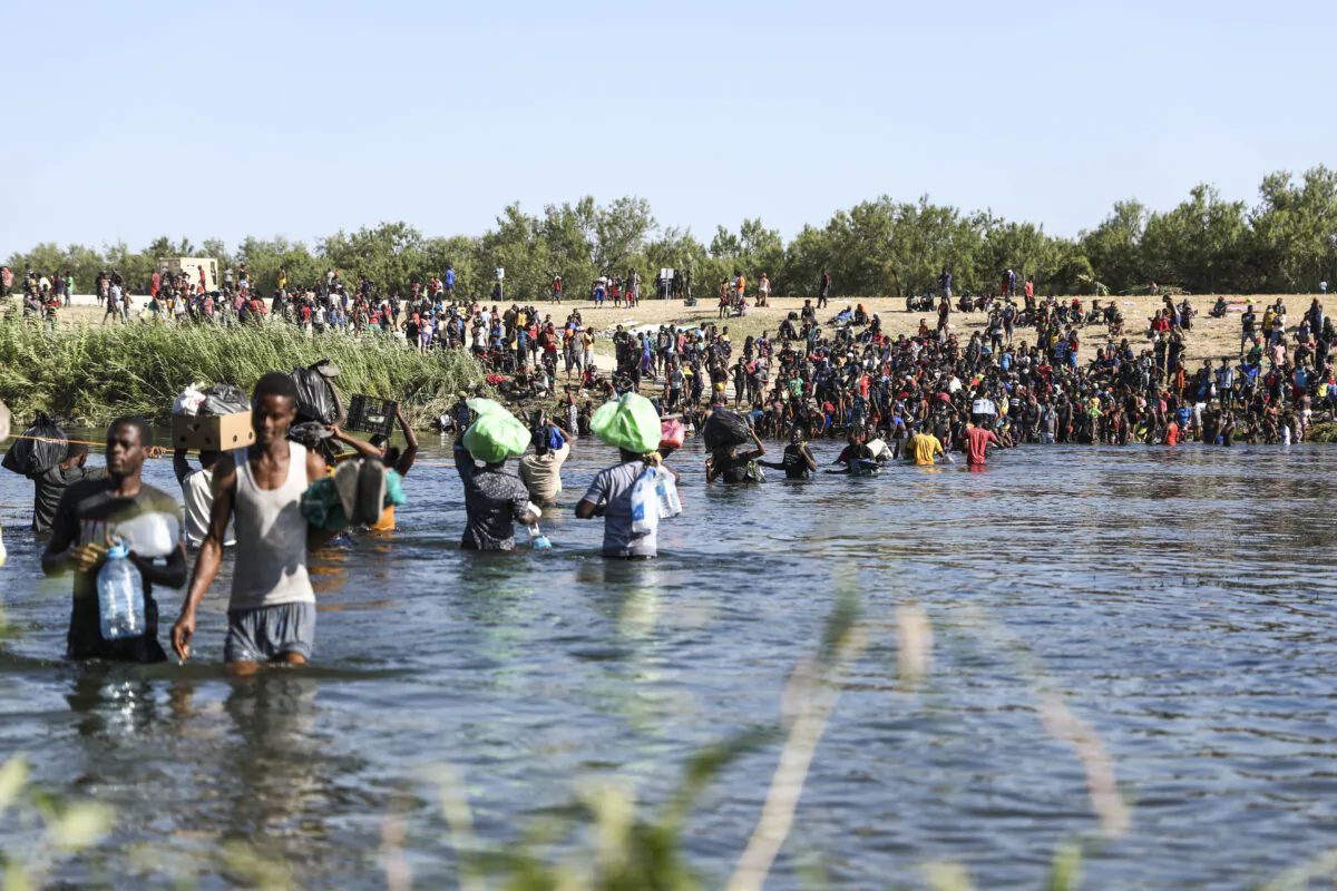 Illegal immigrants cross the Rio Grande between Del Rio, Texas (far side) and Acuña, Mexico on Sept. 20, 2021. (Charlotte Cuthbertson/The Epoch Times)
