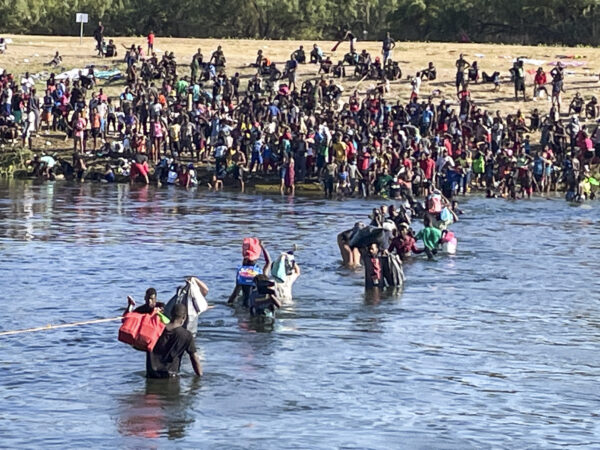 Illegal immigrants cross the Rio Grande between Del Rio (far side) and Acuna, Mexico. Some are crossing back to Mexico to avoid deportation from the United States, in Acuna, Mexico, Sept. 20, 2021. (Charlotte Cuthbertson/The Epoch Times)